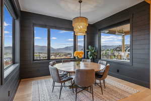 Dining area featuring wood walls, a chandelier, a mountain view, and light hardwood / wood-style floors