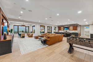 Rec room featuring bar area, a wealth of natural light, and light hardwood / wood-style flooring