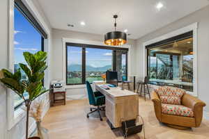 Office with a mountain view and light hardwood / wood-style floors