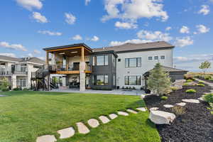 Rear view of house with a patio area, stairway, a yard, and a shingled roof