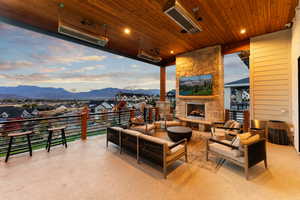 Patio terrace at dusk featuring a mountain view and an outdoor living space with a fireplace