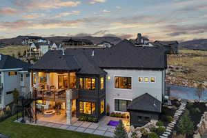 Back house at dusk with a patio area, an outdoor fire pit, and a mountain view