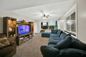 Carpeted living room with ceiling fan