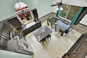 Living room with a towering ceiling, plenty of natural light, sink, and ceiling fan