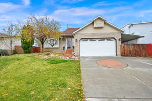 Ranch-style house featuring a garage and a front lawn