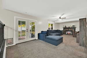 Living room featuring carpet flooring, french doors, and ceiling fan