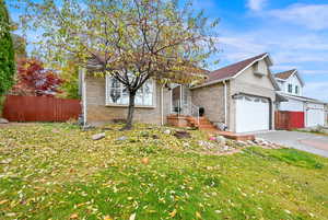 View of front of property featuring a garage and a front yard