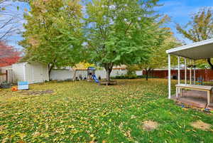 View of yard featuring a playground and a storage unit