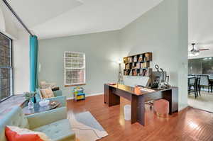 Office area featuring high vaulted ceiling, wood-type flooring, and ceiling fan