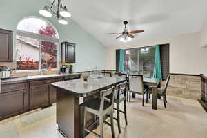 Kitchen featuring dark brown cabinetry, a kitchen breakfast bar, sink, and a kitchen island