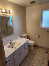 Bathroom featuring toilet, vanity, and tile patterned floors