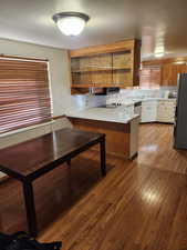 Kitchen featuring kitchen peninsula, stainless steel appliances, and hardwood / wood-style floors