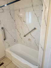 Bathroom with shower / bath combination and tile patterned flooring