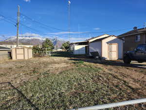 View of yard with a mountain view and a storage unit