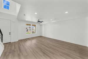 Unfurnished living room featuring ceiling fan and light wood-type flooring