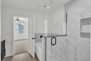 Bathroom featuring hardwood / wood-style floors, independent shower and bath, ceiling fan, and vanity