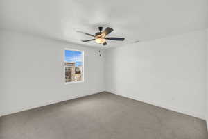 Spare room featuring carpet and ceiling fan