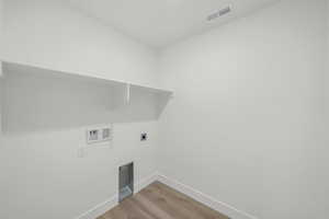 Washroom featuring light hardwood / wood-style floors, electric dryer hookup, and hookup for a washing machine