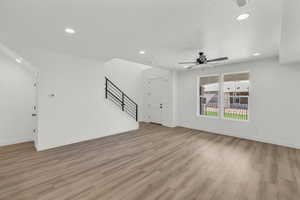 Unfurnished living room featuring light hardwood / wood-style floors and ceiling fan