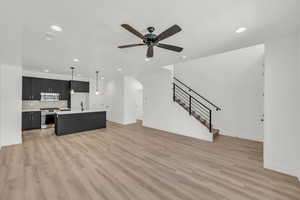 Living room featuring sink, ceiling fan, and light hardwood / wood-style flooring