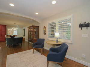 Sitting room with dark hardwood / wood-style floors and a notable chandelier