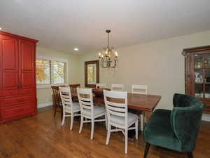 Dining area featuring dark wood-type flooring and a chandelier