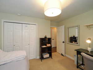 Carpeted bedroom with a closet