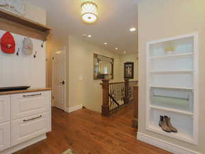 Hallway featuring built in features and dark hardwood / wood-style floors