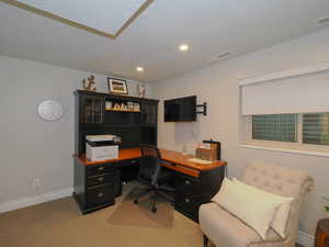 Carpeted home office featuring a textured ceiling