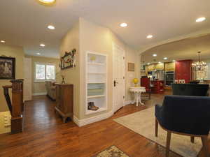 Hallway with dark hardwood / wood-style flooring and a notable chandelier