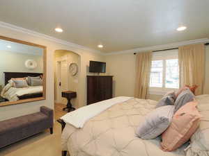 Carpeted bedroom with ornamental molding