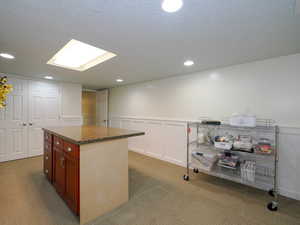 Kitchen with carpet floors, a textured ceiling, and a kitchen island