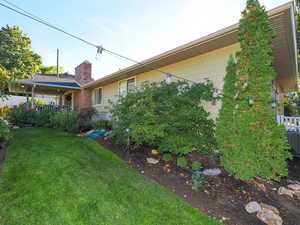 View of side of home featuring a lawn