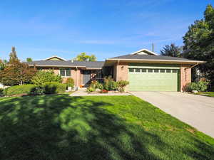 Ranch-style home featuring a front lawn and a garage