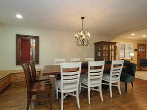 Dining space with dark hardwood / wood-style flooring and a notable chandelier