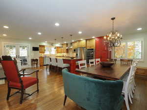 Dining space featuring french doors, hardwood / wood-style floors, a notable chandelier, and sink