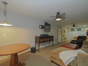 Carpeted living room with ceiling fan