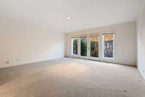 Carpeted spare room featuring crown molding