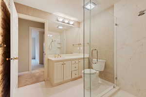 Bathroom with walk in shower, vanity, and toilet