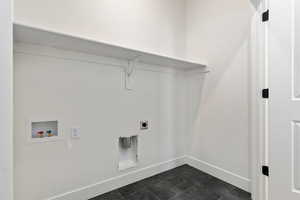 Laundry area with washer hookup, electric dryer hookup, and dark tile patterned flooring