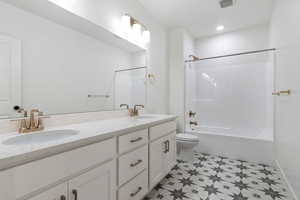 Full basement bathroom featuring a double vanity