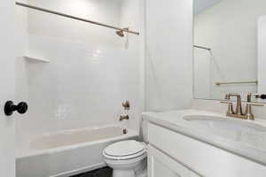 Full bathroom with tile patterned flooring, tiled shower / bath, toilet, and vanity