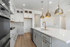 Kitchen with an island with double ovens, wood hood, and designer finishes