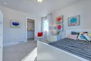 Carpeted bedroom with a closet and a walk in closet