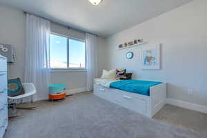 Bedroom featuring light colored carpet and a textured ceiling