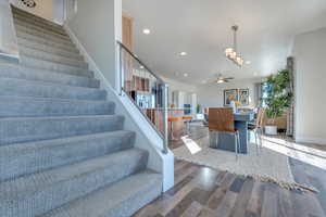 Staircase featuring wood-type flooring and ceiling fan