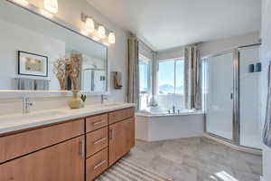 Bathroom featuring vanity, tile patterned floors, and separate shower and tub