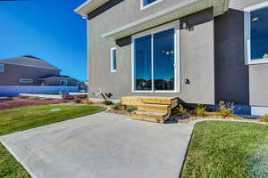 Entrance to property with a lawn and a patio area