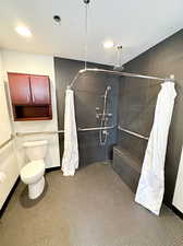 Bathroom featuring toilet and a shower with shower curtain