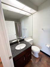 Full bathroom featuring toilet, vanity, shower / bath combination with curtain, and tile patterned flooring